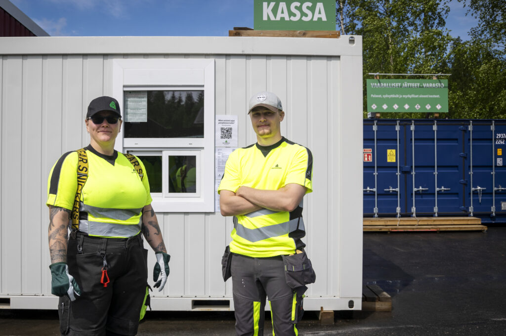 Nainen ja mies seisovat Laukaan pienjäteasemalla kassakopin edessä