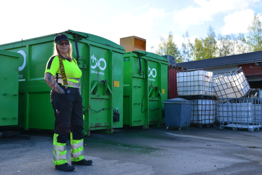 Nainen seisoo vihreän SER-kontin edessä