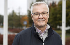 Mies hymyilee kainosti kameralle
