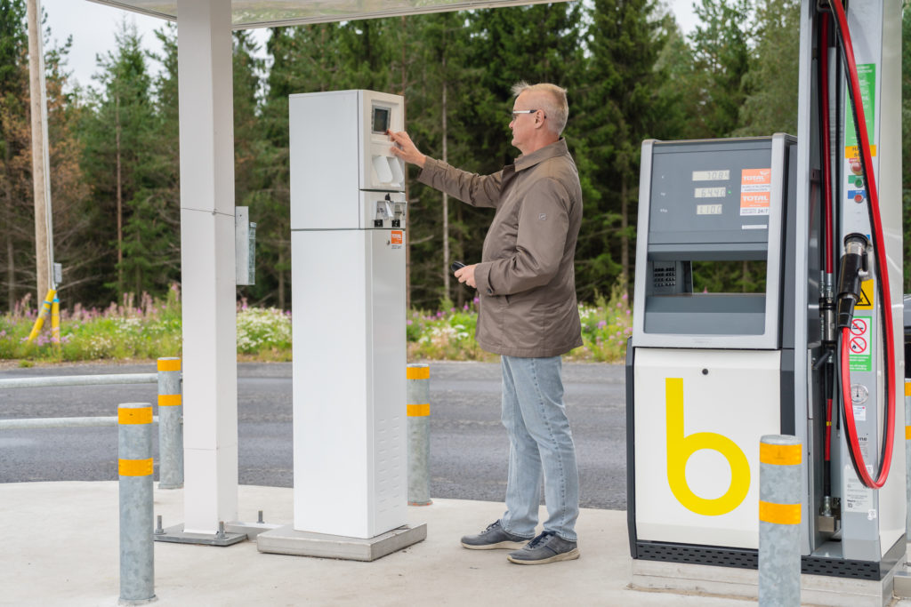 Mies maksamassa biokaasun tankkausta