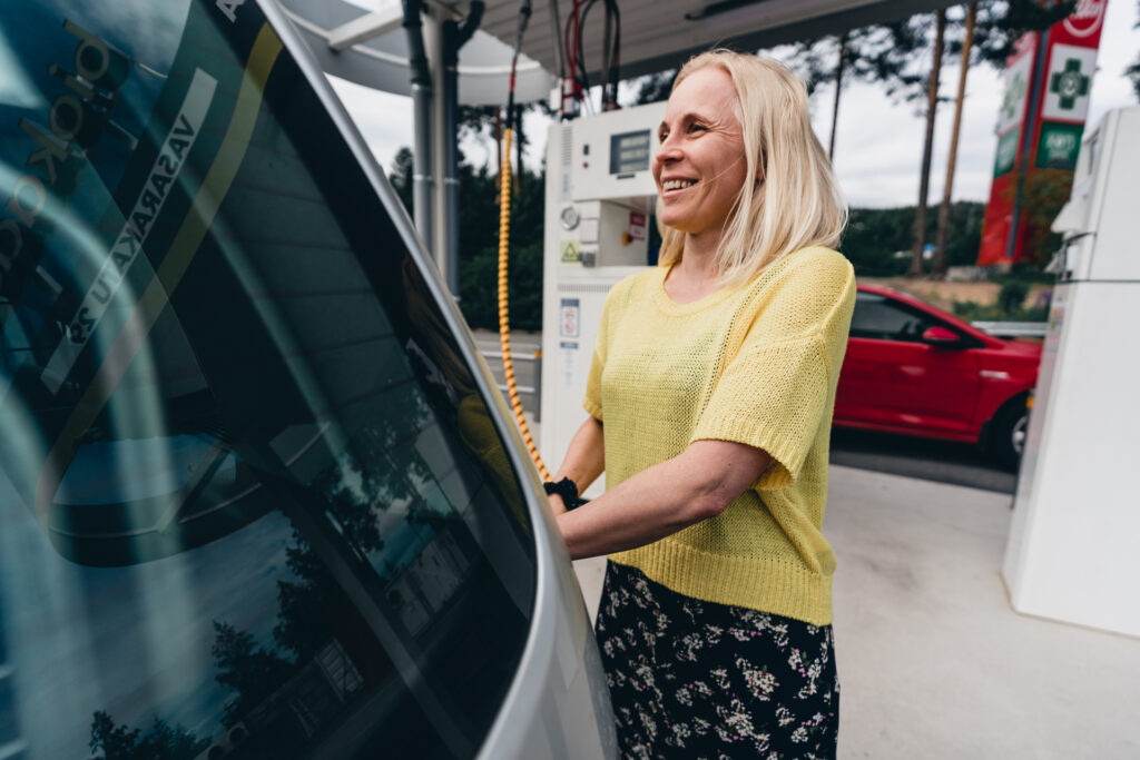 Nainen tankkaa biokaasuautoaan