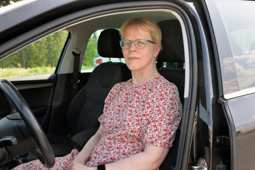 Tiina Pakarinen istuu kaasuautonsa etupenkillä.