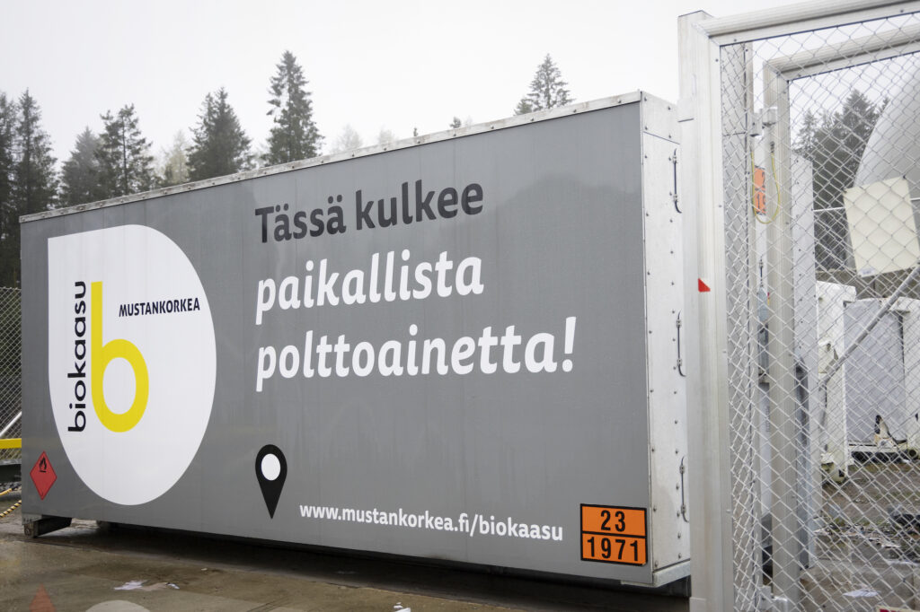 Mustankorkean biokaasukontin kyljessä lukee: Tässä kulkee paikallista polttoainetta.