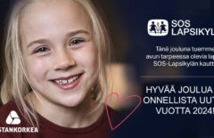 Joulukortissa iloinen pikkutyttö hymyilee kameralle.