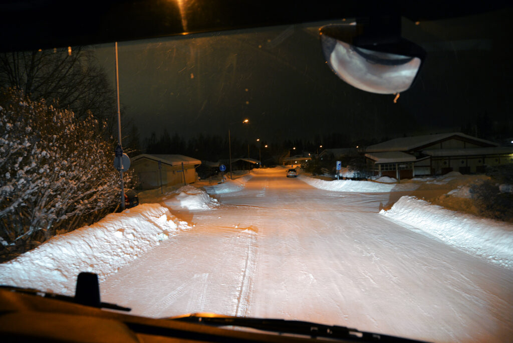 Näkymä jäteauton ohjaamosta pimeälle kadulle. On varhainen arkiaamu Jyväskylässä.