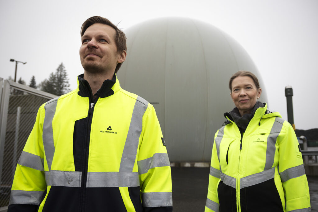 Kaksi Mustankorkean työntekijää seisoo biokaasulaitoksen edustalla