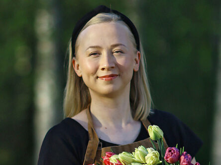 Naisella on kädessään kimpu tulppaaneja.