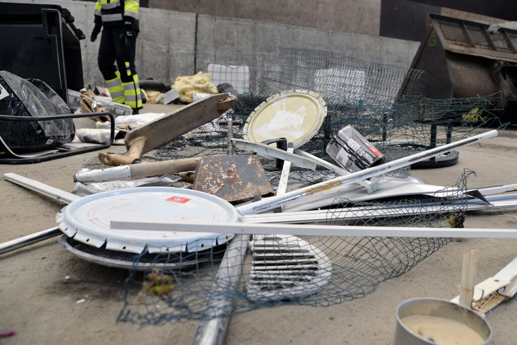 Hallin betonilattialla näkyy erilaisia metallisia jätteitä.