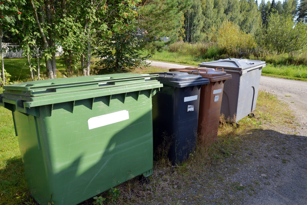 Neljä erikokoista ja väristä jäteastiaa yhdessä ryppäässä jossain risteyksessä.