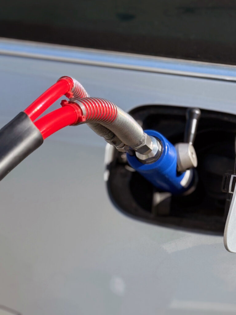 Takana on auto ja siinä on kiinni jonkinlainen tankkausliitin.