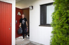 Nuori mies on tulossa rivitaloasunnosta ulos. Kädessä hänellä on roskapusseja. On kesä.