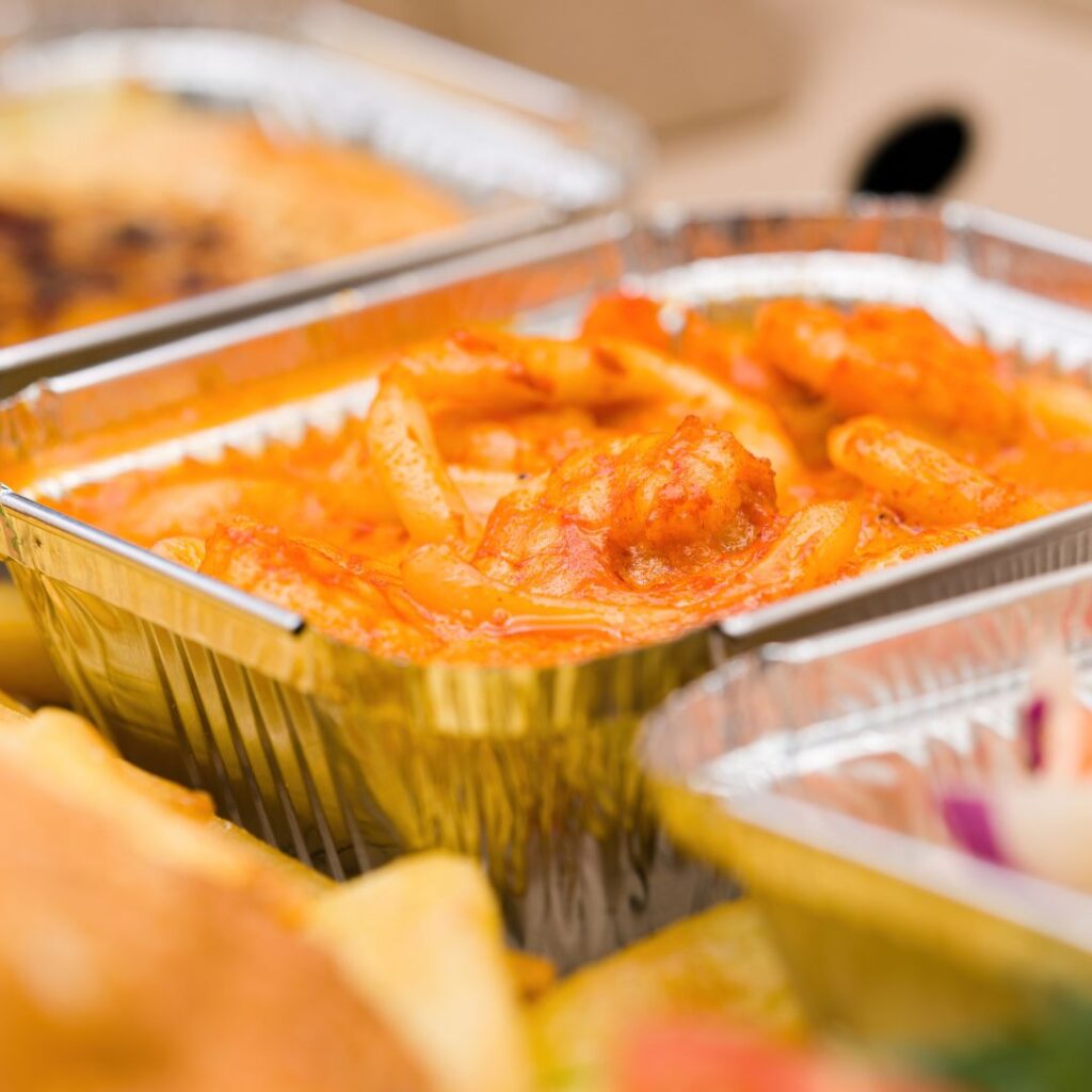 Pöydällä on foliolaatikoissa joululaatikoita, olisikohan ehkä porkkanalaatikkoa.