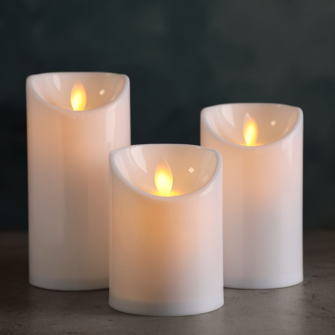 Pöydällä on kolme valkoista led-kynttilää.