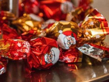 Lautasella on punaisia joulukarkkeja.