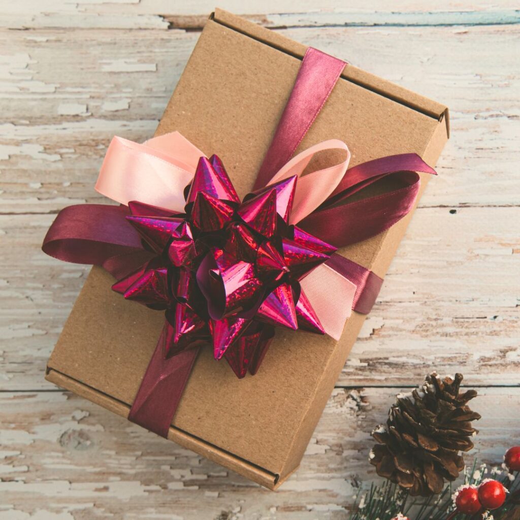 Pöydällä on paketti, jossa on kiedottuna lahjanauhat.