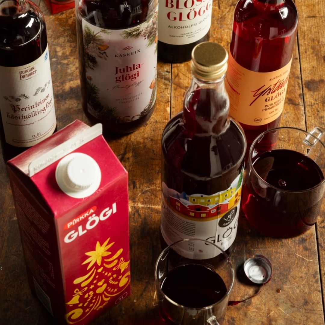 Puisella pöydällä on erilaisia glögejä. Etualalla on Pirkan glögi, muut ovat lasipulloissa.