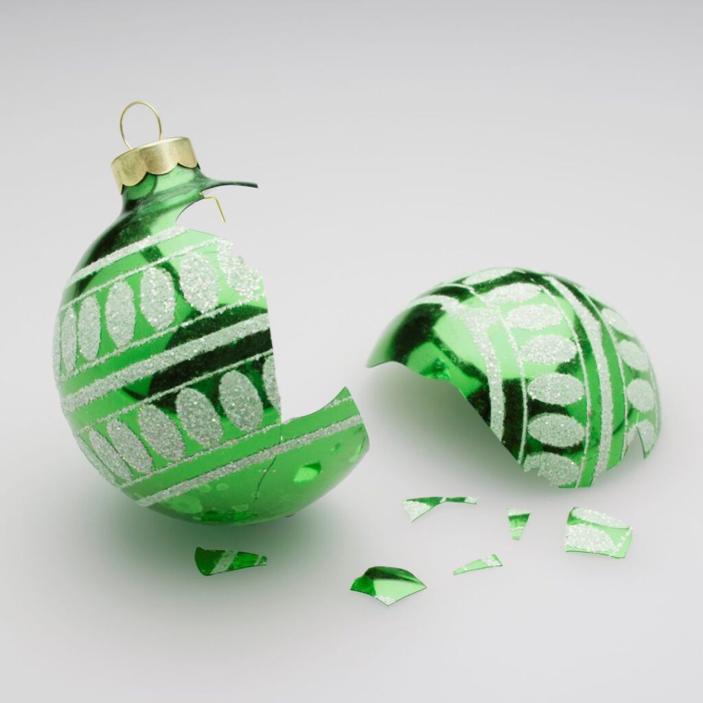 Kuvassa on vihreä rikkoutunut joulukoriste.