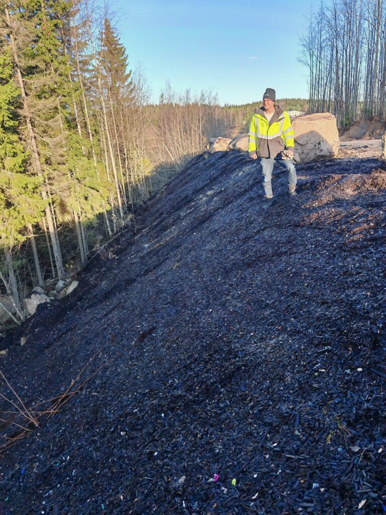 Mies seisoo jyrkän penkereen reunalla. Aurinko häikäisee ja on kaunis syyspäivä.
