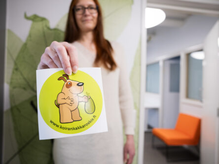 Nainen pitää kädessää koirankakkatarraa.