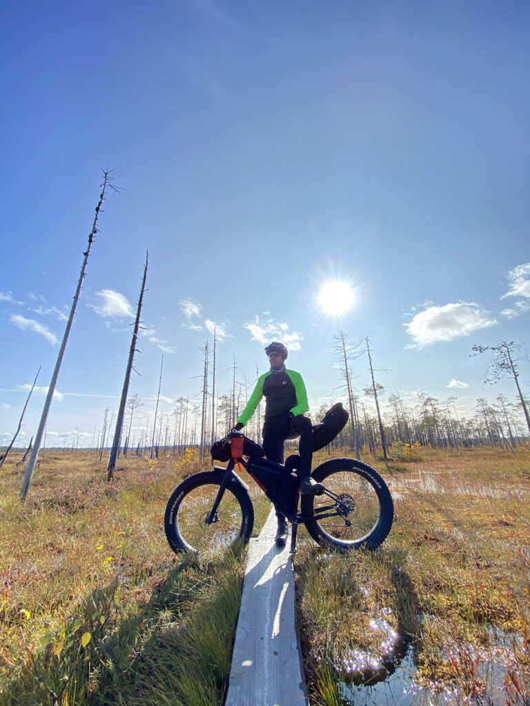Mies on pyörällä jossain soisella alueella. Ilma on todella kaunis.