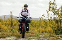 Mies on retkipyöräilemässä jossain pohjoisessa. Vuodenaika näyttää syksyltä ja hänellä on pyörän kyydissä paljon tavaraa.