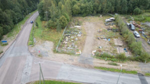 Ilmakuva jostain alueesta, jonka vieressä menee mäki alaspäin ja sitä ajaa auto.