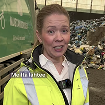 Nainen on huomiotakki päällä jossain jätehallissa.